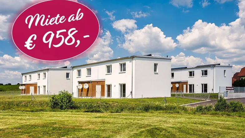 Moderne Reihenhäuser in ländlicher Umgebung mit Mietpreisangabe auf dem Bild.