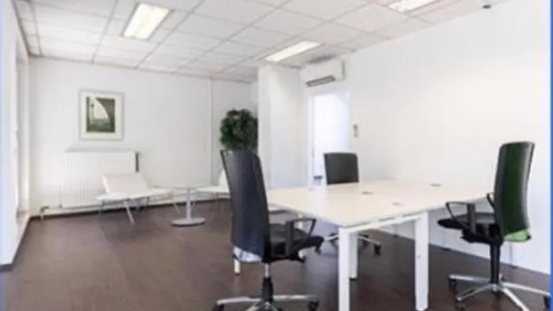 Helles Büro mit mehreren Arbeitsplätzen, dunklem Boden und abgehängter Decke.