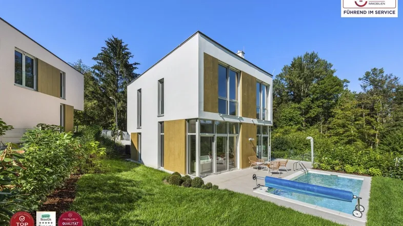 Moderne Villa mit Pool und Garten in sonniger Lage, umgeben von viel Grün.