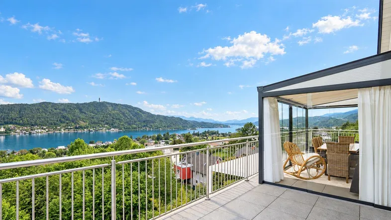 Große Terrasse mit Glasüberdachung, Essbereich und atemberaubendem Blick auf den See und die Berge.