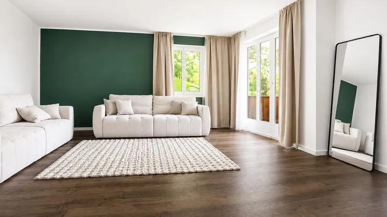Helles Wohnzimmer mit modernem Design, dunklem Holzboden und einer grünen Akzentwand.