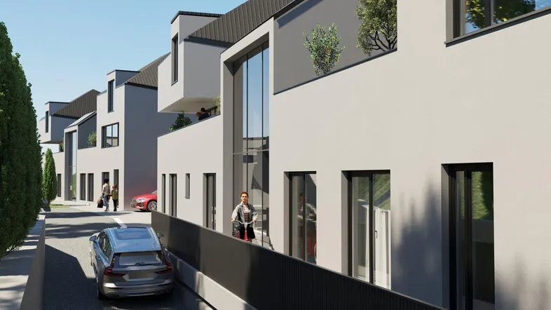 Moderne Reihenhäuser mit großen Glasfronten und Balkonen entlang einer ruhigen Straße.