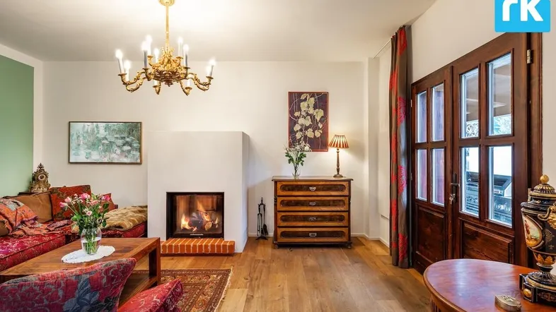 Gemütliches Wohnzimmer mit Kamin, Holzboden und traditionellen Möbeln, ideal zum Entspannen.
