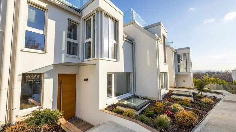 Moderne Architektur mit weißer Fassade, großen Fenstern und gepflegter Gartenanlage.