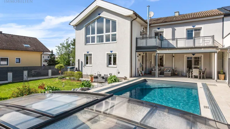 Modernes Einfamilienhaus mit großem Garten, Swimmingpool und möblierter Terrasse für entspannte Stunden im Freien.