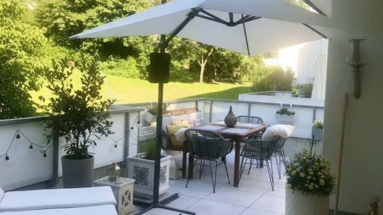 Geräumige Terrasse mit bequemen Gartenmöbeln, Sonnenschirm und Blick ins Grüne.