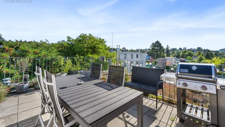 Große Dachterrasse mit Esstisch, Grill und weitem Blick ins Grüne, ideal für entspannte Stunden im Freien.
