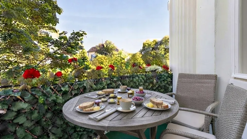 Frühstück am Balkon mit Grünblick (KI hat den Tisch gedeckt)