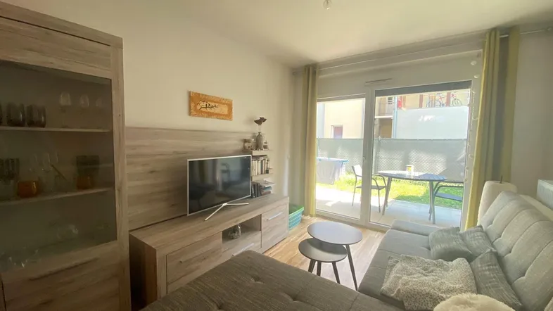 Helles Wohnzimmer mit Holzboden, gemütlichem Sofa und direktem Zugang zur Terrasse.