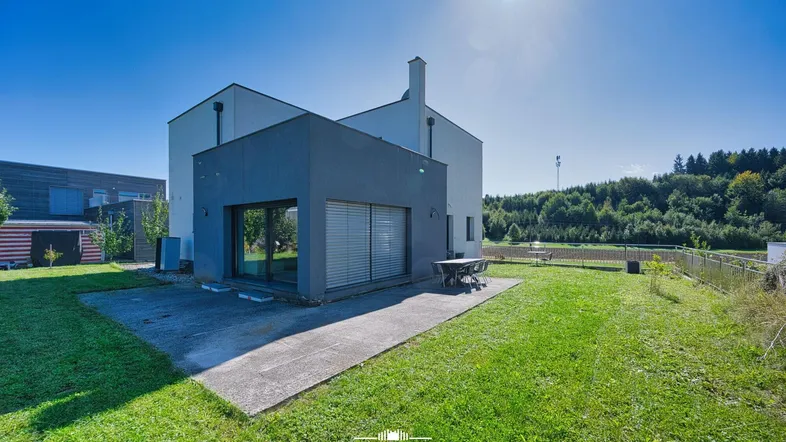 Modernes Einfamilienhaus mit großer Rasenfläche, sonniger Terrasse und Blick ins Grüne.