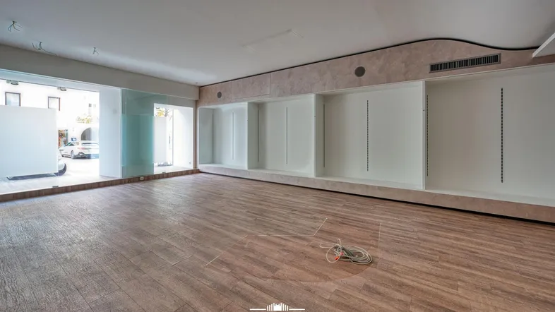 Geräumiger, leerer Ladenbereich mit großen Schaufenstern und eingebauten Regalsystemen, bereit zur Gestaltung.