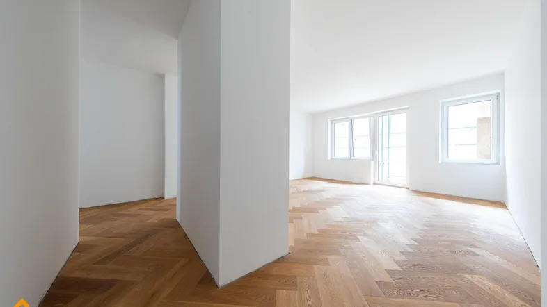 Helles Zimmer mit Fischgrätparkett und weißen Wänden, bereit zur individuellen Gestaltung.