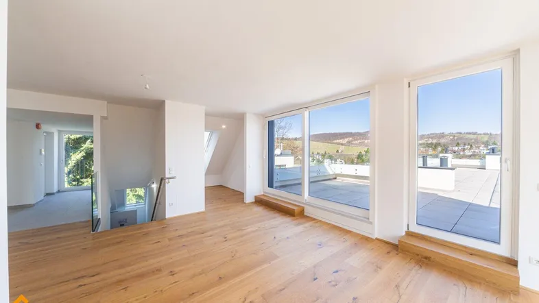 Helles, geräumiges Wohnzimmer mit Holzboden und großen Fenstern, die auf eine Dachterrasse führen.