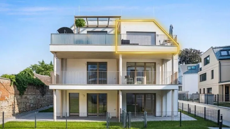 Modernes Mehrfamilienhaus mit mehreren Balkonen und Dachterrasse in sonniger Lage.