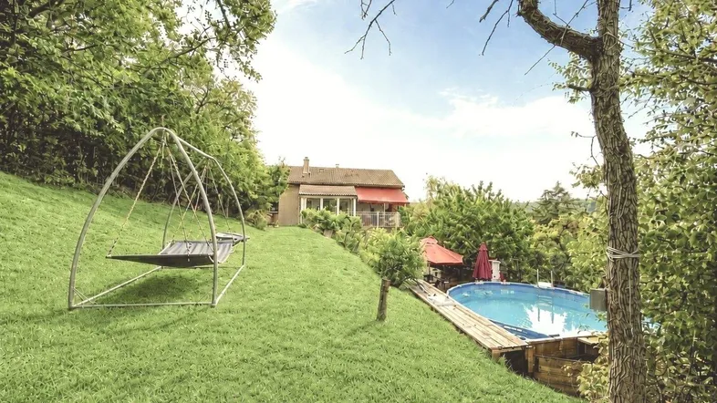Großer Gartenbereich mit Schaukel, oberirdischem Pool und Blick auf das Haus und die umliegende Landschaft.