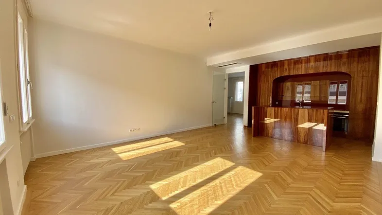 Helles Wohnzimmer mit Fischgrätparkett, Holzelementen und viel natürlichem Licht.