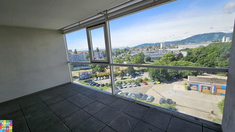 Geräumiger Balkon mit Fliesenboden und weitem Blick über die Stadt und die umliegenden Berge.