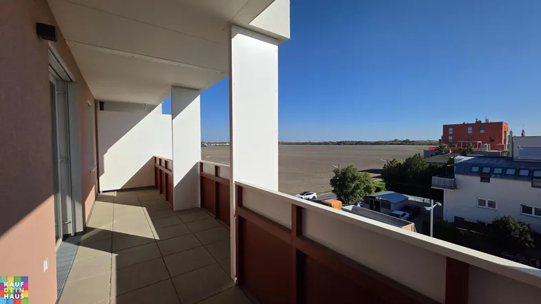 Geräumiger Balkon mit Fliesenboden und weitem Blick über Felder und die Umgebung.