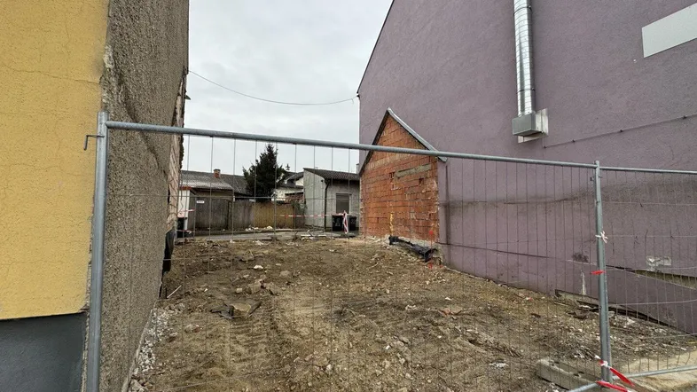 Leeres Baugrundstück zwischen zwei Gebäuden, bereit für die zukünftige Bebauung in urbaner Umgebung.