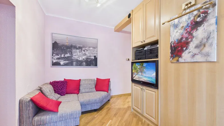 Gemütliches Wohnzimmer mit Ecksofa, Holzboden und integriertem Mediaschrank.