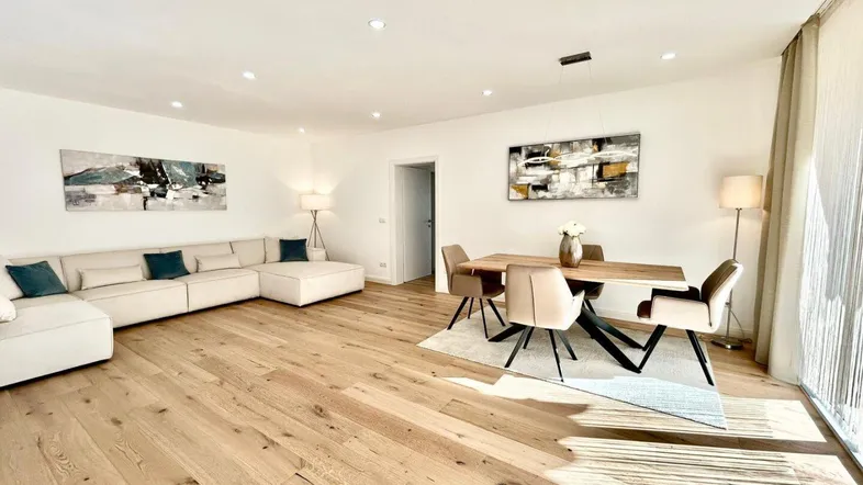 Heller, offener Wohn-Essbereich mit modernem Design, Holzboden und viel Tageslicht.