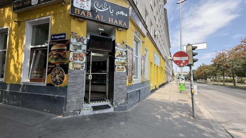 Außenansicht eines Eckgebäudes mit einem Restaurant im Erdgeschoss und Blick auf die Straße.