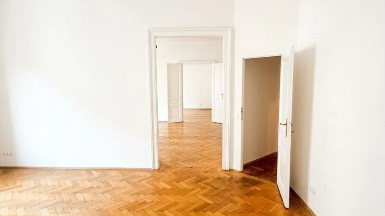 Helles Zimmer mit Fischgrätparkett und hohen Decken, bereit für individuelle Gestaltung.