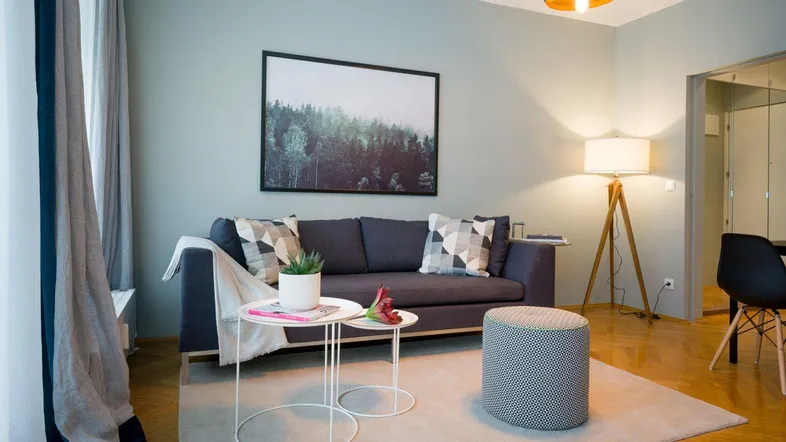 Modernes Wohnzimmer mit Fischgrätparkett, bequemer Couch und stilvoller Dekoration.