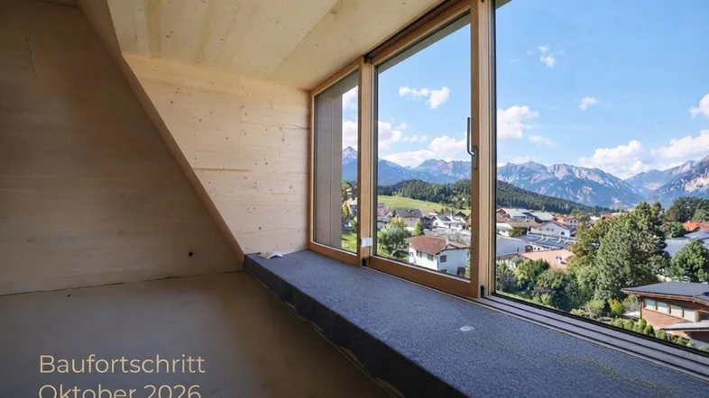 Unfertiger Innenraum mit Holzwänden und großen Fenstern, die einen weiten Bergblick bieten.