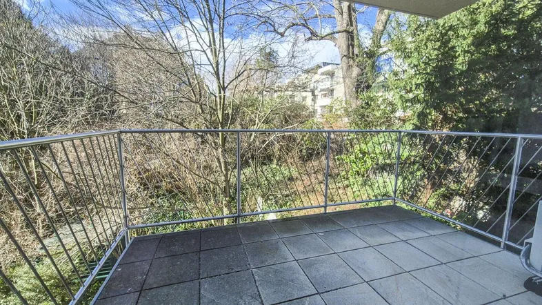 Geräumiger Balkon mit Fliesenboden und Blick ins Grüne, ideal zum Entspannen im Freien.