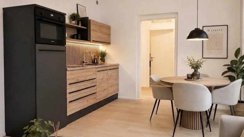 Moderne offene Küche mit integrierten Geräten und Essbereich in hellem Ambiente.