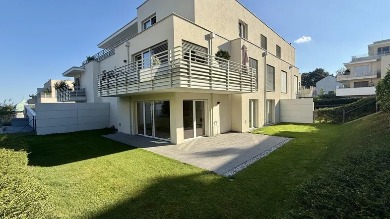 Moderne Wohnanlage mit großzügiger Terrasse und privatem Gartenbereich im Erdgeschoss.