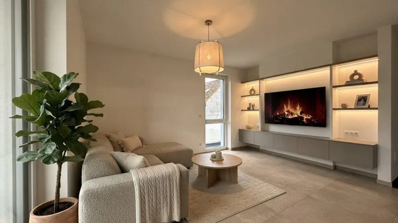 Virtuell inszeniertes Wohnzimmer mit gemütlichem Sofa, modernem Medienregal und Blick nach draußen.
