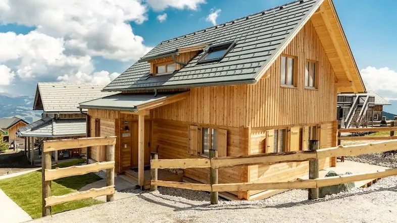 Charmantes Holzhaus im Chalet-Stil mit Satteldach und ländlicher Umgebung.
