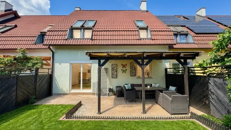 Gemütliche Terrasse mit Überdachung und Gartenbereich, ideal für entspannte Stunden im Freien.