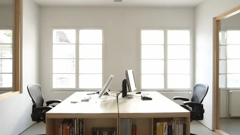 Helles und modernes Büro mit zwei Arbeitsplätzen, großen Fenstern und viel natürlichem Licht.