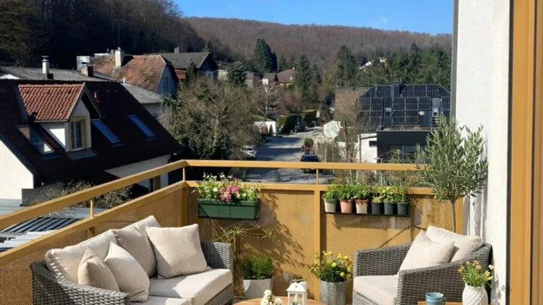 Möblierter Balkon mit bequemen Sitzgelegenheiten und weitem Blick über die umliegende Landschaft.