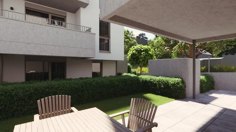 Moderne Terrasse mit Gartenmöbeln und Blick auf die Wohnanlage, umgeben von Grünflächen.