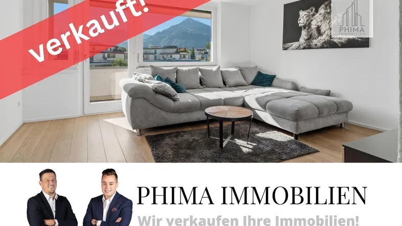 Helles Wohnzimmer mit großem Sofa, Holzboden und Bergblick durch die Fenster.