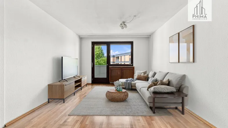 Helles Wohnzimmer mit Parkettboden, Sofa und Zugang zum Balkon, modern eingerichtet.