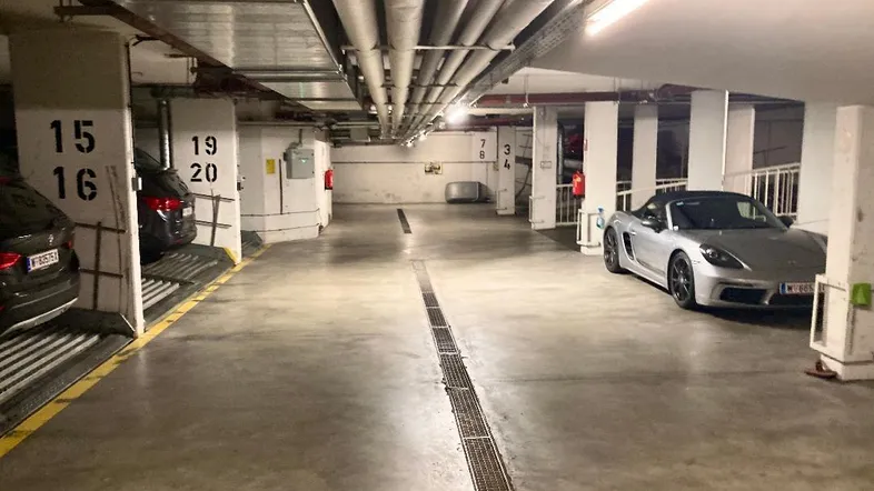Geräumige Tiefgarage mit mehreren Stellplätzen und einem modernen Sportwagen.