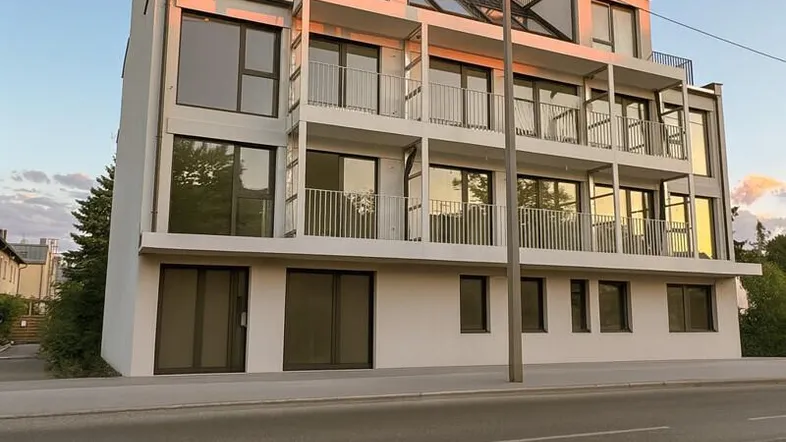 Moderne Wohnanlage mit mehreren Balkonen und Dachterrassen unter einem klaren Abendhimmel.