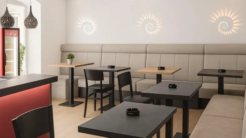 Modern eingerichteter Barbereich mit Sitzbänken, Tischen und stilvoller Beleuchtung.