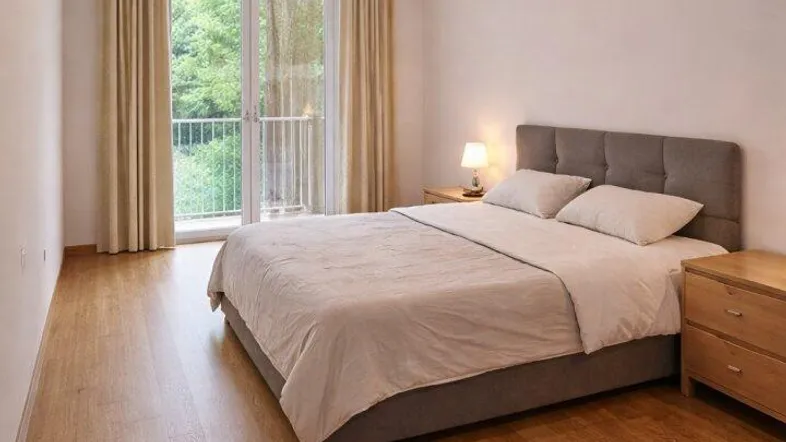 Helles Schlafzimmer mit Doppelbett, Laminatboden und direktem Zugang zum Balkon.