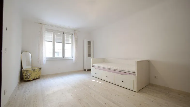 Helles Zimmer mit Tagesbett, Fenster und hellem Holzboden, ideal als Schlaf- oder Gästezimmer.