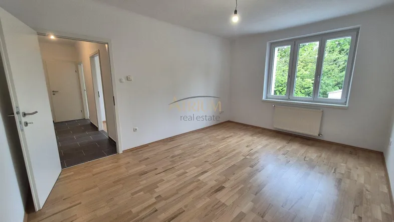 Helles Zimmer mit Parkettboden und Blick ins Grüne, ideal als Wohn- oder Schlafzimmer.