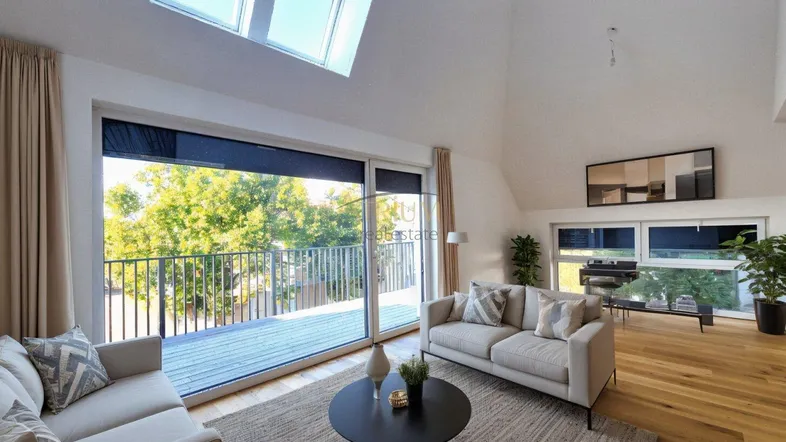 Helles Wohnzimmer im Dachgeschoss mit Holzboden, großen Fenstern und Zugang zu einem Balkon.