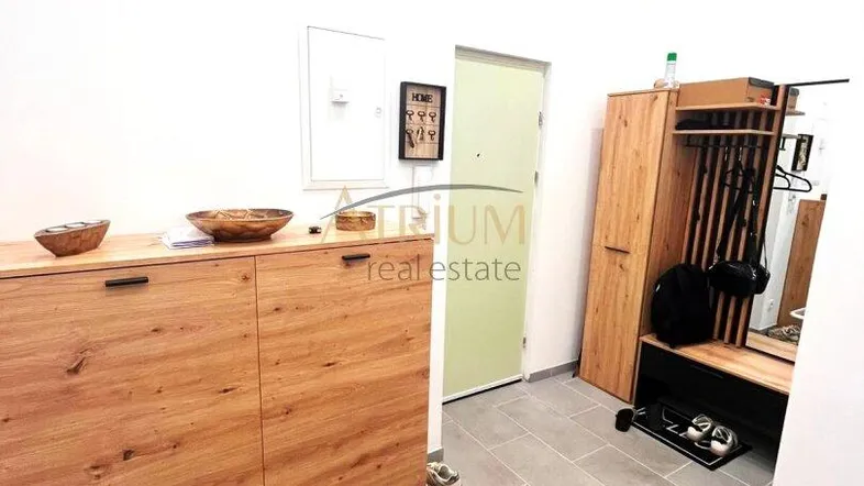 Heller Eingangsbereich mit praktischem Schuhschrank, Garderobe und Fliesenboden.