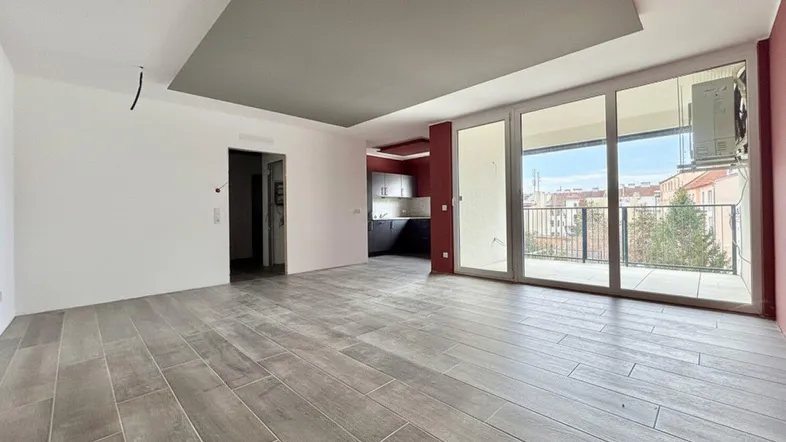 Geräumiger, heller Wohnbereich mit modernen Fliesen, großen Fenstern und Zugang zu einem Balkon.