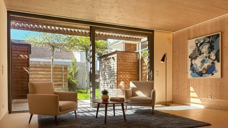 Helles Wohnzimmer mit Holzwänden, großen Schiebetüren und Blick in den Gartenbereich.